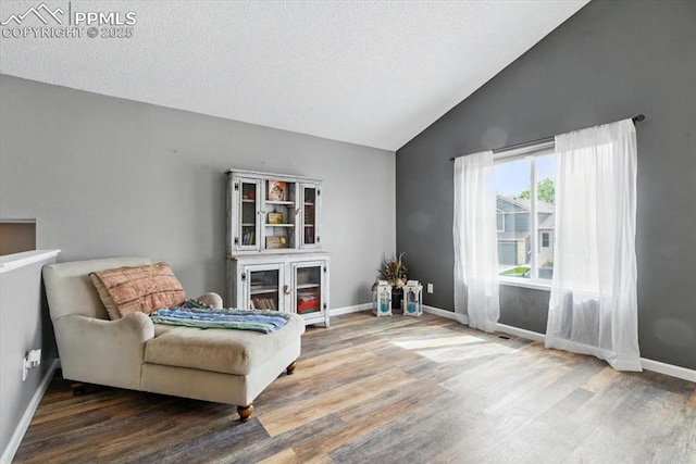 2032 Woodsong Way, Fountain, CO 80817 - sitting room featuring wood finished floors, baseboards, a textured ceiling, and high vaulted ceiling