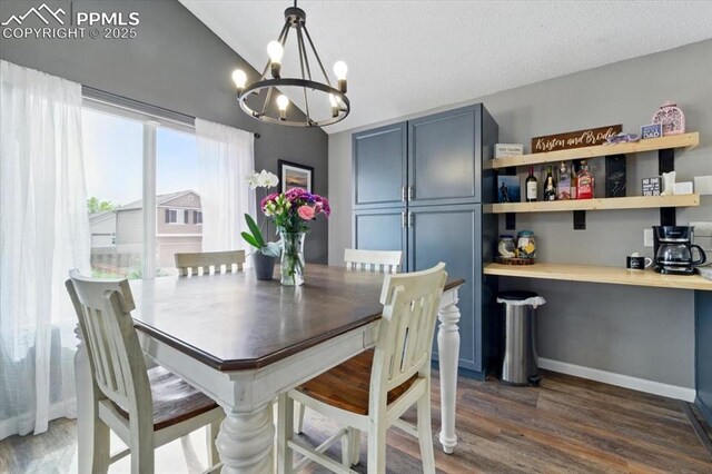 2032 Woodsong Way, Fountain, CO 80817 - dining space featuring a chandelier, vaulted ceiling, and dark wood-style floors