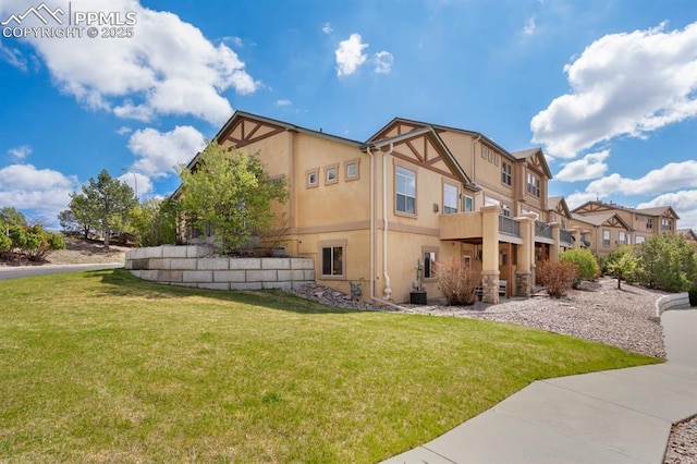 8492 Artesian Springs Pt, Colorado Springs, CO 80920 - view of side of home with stucco siding, a lawn, and a balcony