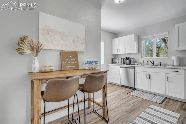 720 S Prospect St, Colorado Springs, CO 80903 - kitchen featuring light wood finished floors, a sink, appliances with stainless steel finishes, and white cabinetry