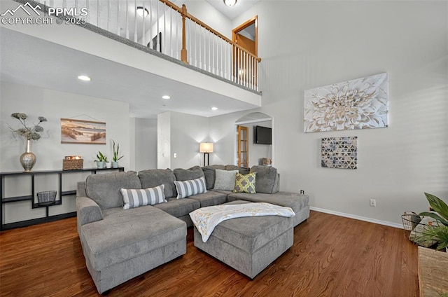 9025 Rochester Dr, Colorado Springs, CO 80920 - living room featuring wood finished floors, baseboards, arched walkways, a high ceiling, and recessed lighting