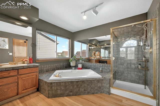 9025 Rochester Dr, Colorado Springs, CO 80920 - full bathroom with wood finished floors, a bath, a shower stall, and vanity