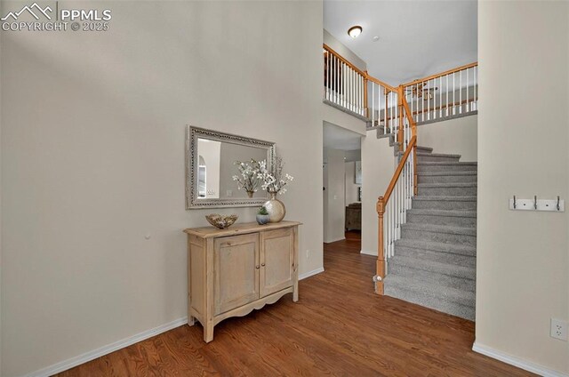 9025 Rochester Dr, Colorado Springs, CO 80920 - stairway featuring wood finished floors, baseboards, and a high ceiling