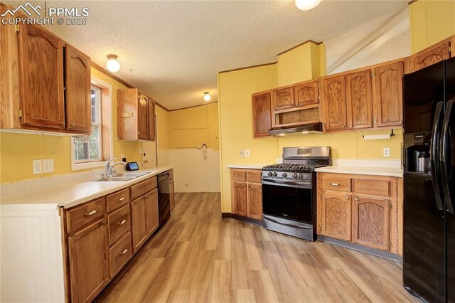 455 Clio Ave, Palmer Lake, CO 80133 - kitchen with black appliances, under cabinet range hood, light wood finished floors, a textured ceiling, and light countertops