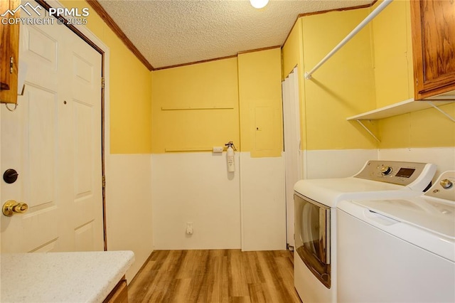 455 Clio Ave, Palmer Lake, CO 80133 - washroom with light wood-style flooring, separate washer and dryer, a textured ceiling, crown molding, and cabinet space