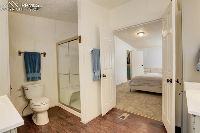 455 Clio Ave, Palmer Lake, CO 80133 - full bath with vanity, a shower stall, a textured ceiling, wood finished floors, and connected bathroom