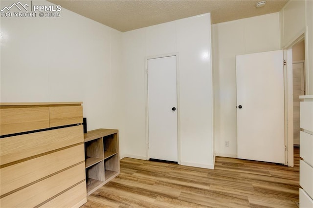 455 Clio Ave, Palmer Lake, CO 80133 - unfurnished bedroom featuring light wood-style floors and a textured ceiling