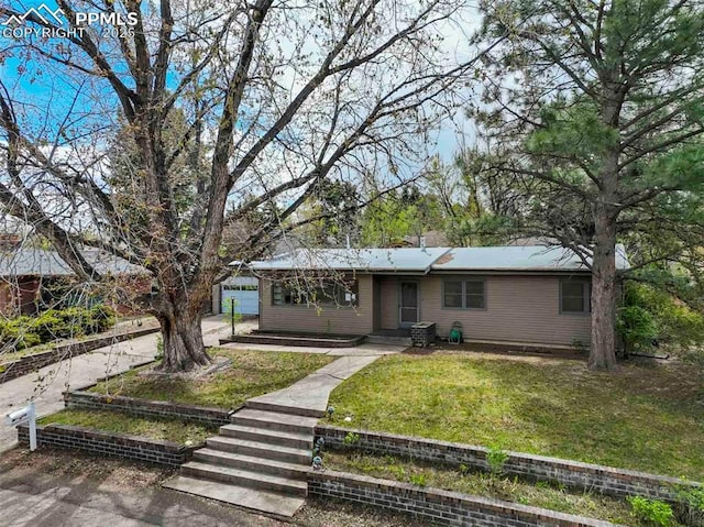 ranch-style home featuring a front yard and concrete driveway