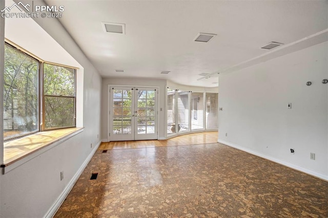 unfurnished room with baseboards, visible vents, and french doors