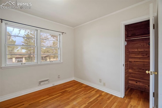 unfurnished bedroom with baseboards, visible vents, light wood-type flooring, and a spacious closet