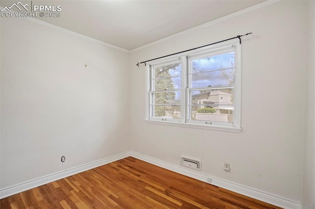 unfurnished room featuring baseboards, ornamental molding, and wood finished floors
