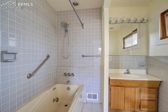 full bathroom with visible vents, tile patterned flooring, vanity, shower / bathtub combination, and tile walls