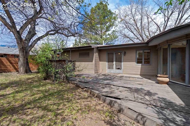 rear view of house featuring fence and a deck