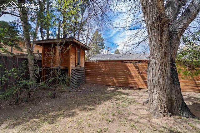 view of yard featuring fence and an outdoor structure