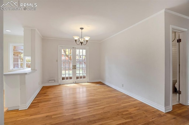 unfurnished dining area featuring light wood-style floors, baseboards, crown molding, and an inviting chandelier