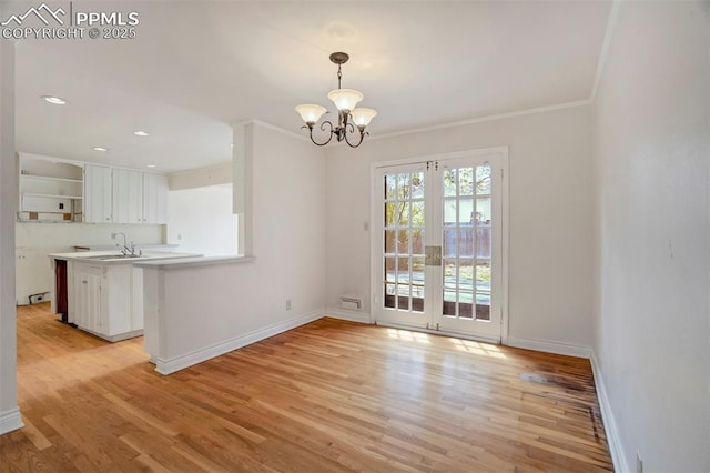 unfurnished dining area with baseboards, light wood-type flooring, and a notable chandelier