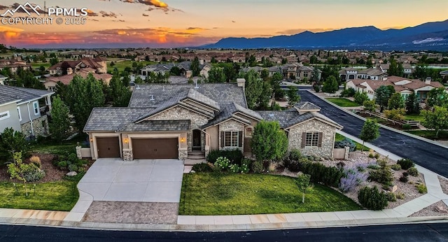 ranch-style house featuring a residential view, a mountain view, concrete driveway, an attached garage, and stone siding