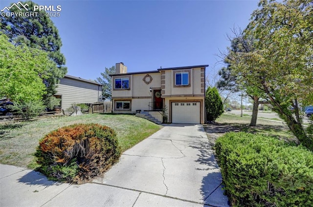 raised ranch with a chimney, an attached garage, stucco siding, concrete driveway, and a front yard