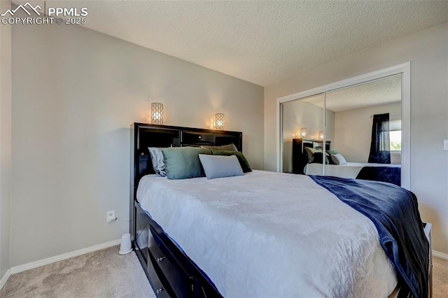 bedroom with light carpet, a textured ceiling, and baseboards
