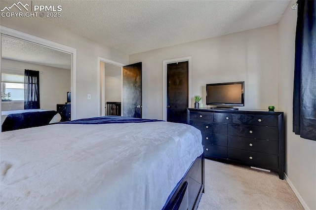 bedroom featuring light carpet, a textured ceiling, and baseboards