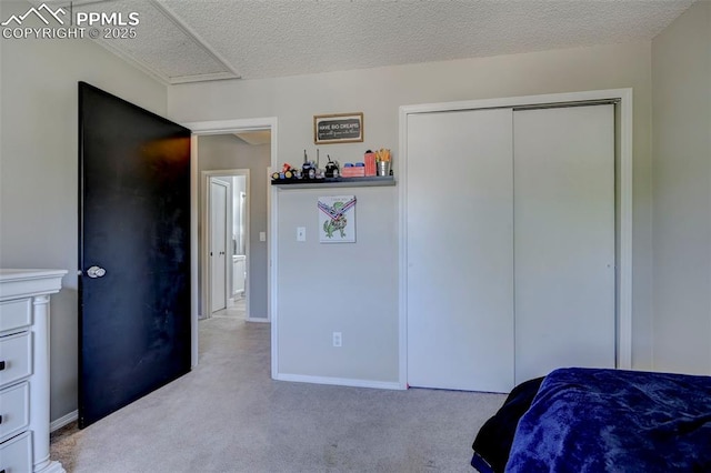 bedroom featuring a textured ceiling, baseboards, a closet, and carpet floors