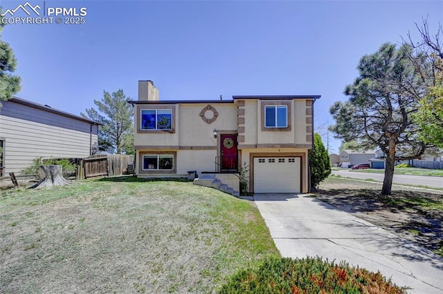 split foyer home with a chimney, fence, a garage, stucco siding, and concrete driveway