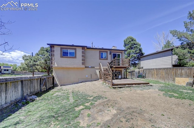 back of property featuring stairs, a deck, and a fenced backyard