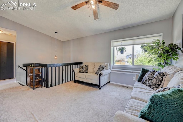 carpeted living area with a textured ceiling, visible vents, baseboards, and a ceiling fan