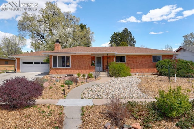 ranch-style home featuring a garage, a chimney, driveway, and brick siding