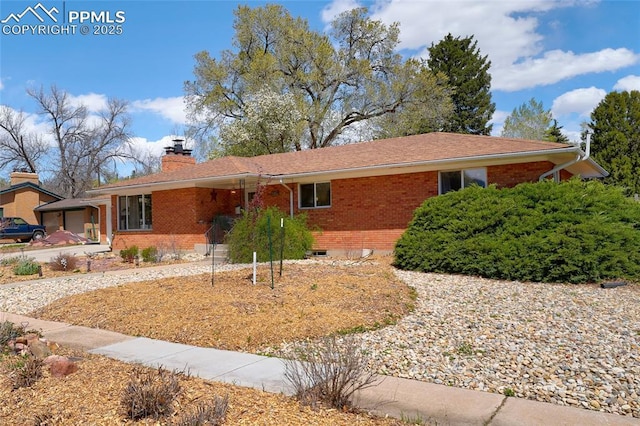 ranch-style house featuring brick siding and a chimney