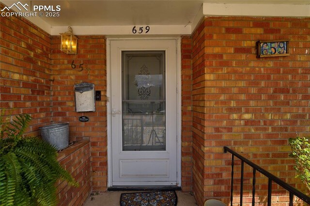 property entrance featuring brick siding