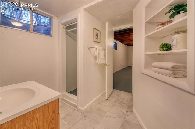 1227 Holmes Dr, Colorado Springs, CO 80909 - bathroom featuring a stall shower, baseboards, marble finish flooring, and vanity