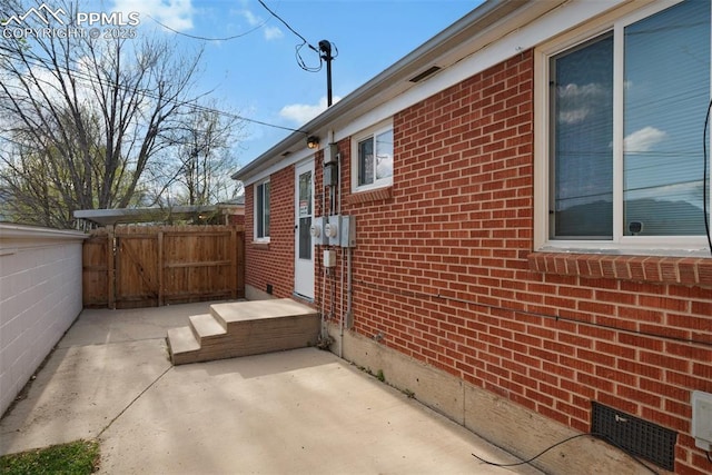 1229 E Caramillo St, Colorado Springs, CO 80909 - view of home's exterior featuring brick siding, a gate, a patio area, crawl space, and fence