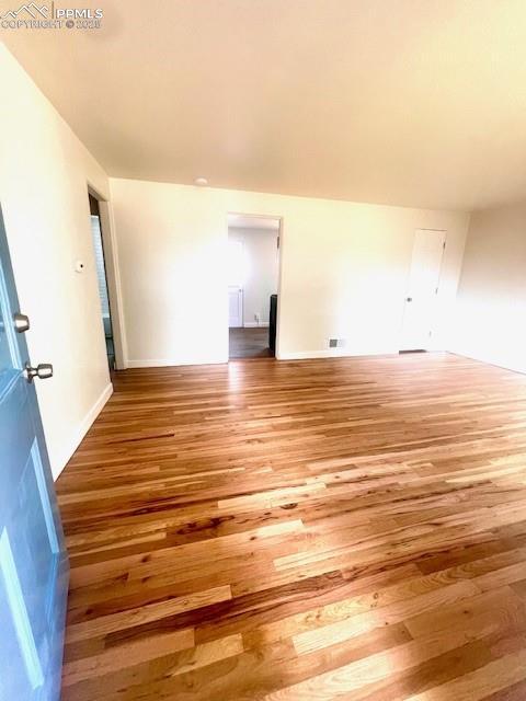 1229 E Caramillo St, Colorado Springs, CO 80909 - empty room featuring wood finished floors and baseboards