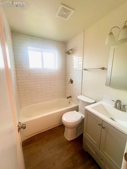 1229 E Caramillo St, Colorado Springs, CO 80909 - full bath featuring wood finished floors, toilet, shower / bathtub combination, and vanity