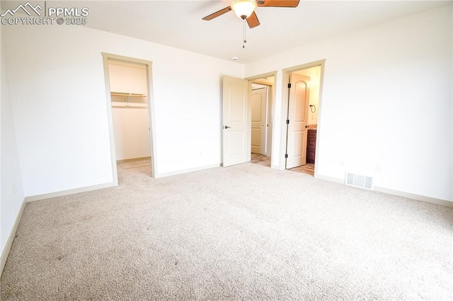 unfurnished bedroom with visible vents, carpet flooring, baseboards, and a spacious closet