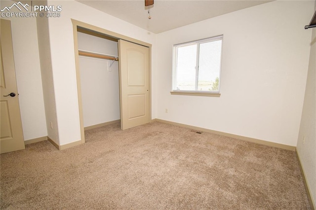 unfurnished bedroom with baseboards, light colored carpet, visible vents, and a closet