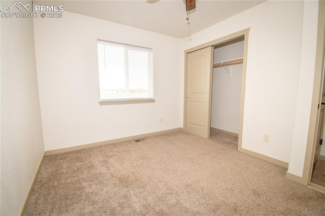 unfurnished bedroom with a closet, baseboards, a ceiling fan, and carpet flooring