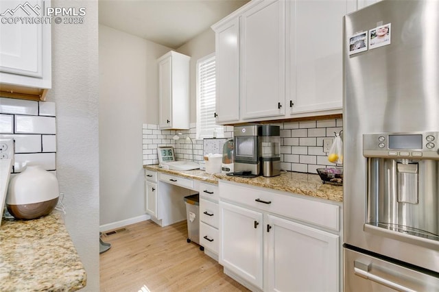 3111 Youngheart Way, Castle Rock, CO 80109 - kitchen featuring stainless steel fridge with ice dispenser, decorative backsplash, white cabinetry, and light wood-style floors