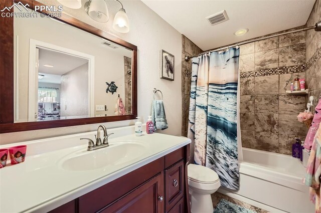 full bathroom with visible vents, shower / tub combo, toilet, and vanity