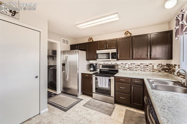 kitchen featuring dark brown cabinetry, appliances with stainless steel finishes, a sink, light countertops, and visible vents