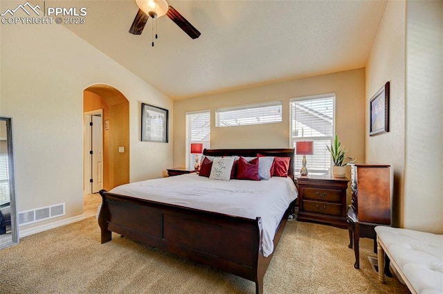 carpeted bedroom featuring arched walkways, multiple windows, lofted ceiling, and visible vents