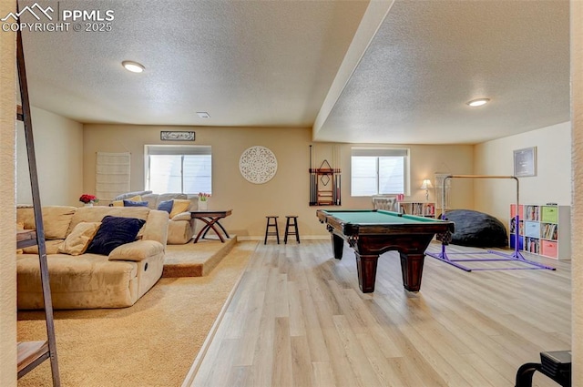 playroom featuring pool table, a textured ceiling, a healthy amount of sunlight, and wood finished floors