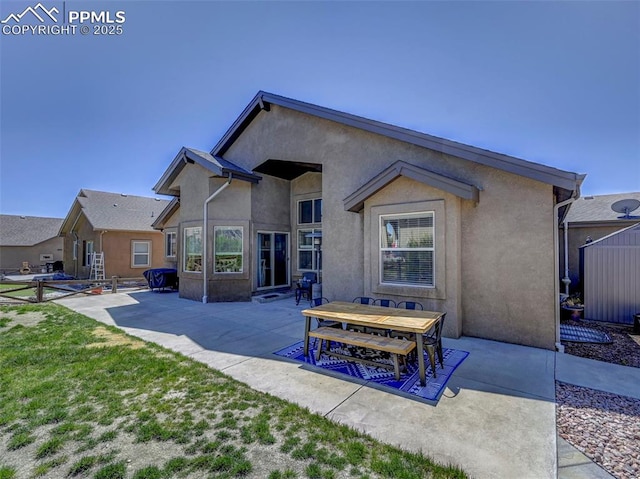 rear view of house with a patio and stucco siding