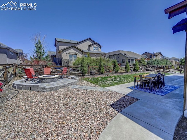 view of yard featuring a residential view, a fire pit, outdoor dining area, and a patio area