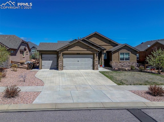 view of front of house featuring an attached garage, stucco siding, driveway, and stone siding