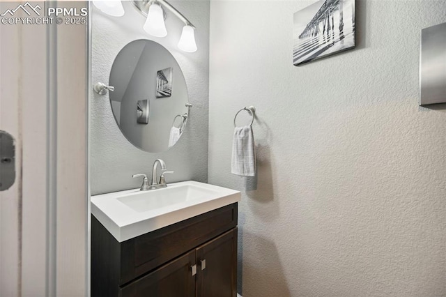 bathroom with vanity and a textured wall