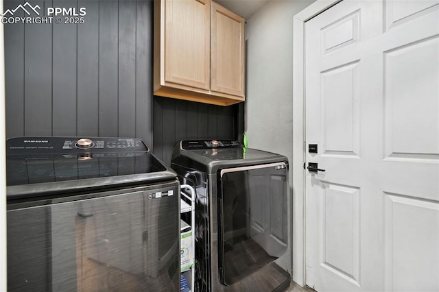 clothes washing area with cabinet space and washing machine and dryer