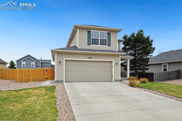 traditional-style house featuring a garage, fence, driveway, and a front yard