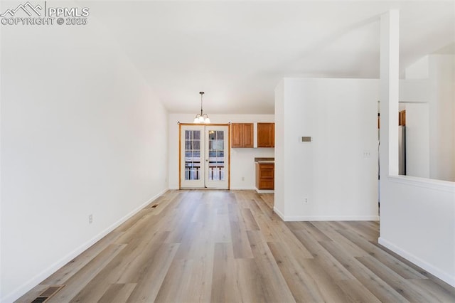 2706 N Chestnut St, Colorado Springs, CO 80907 - unfurnished living room featuring light wood finished floors, a chandelier, baseboards, and french doors